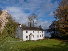 A house near a lake surrounded by trees at Hullet Hall in Graythwaite near Hawkshead