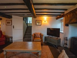A living room with a sofa and television at Hullet Hall Graythwaite near Hawkshead