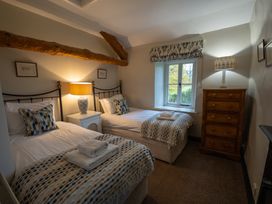 A bedroom with two beds and a window at Hullet Hall Graythwaite near Hawkshead
