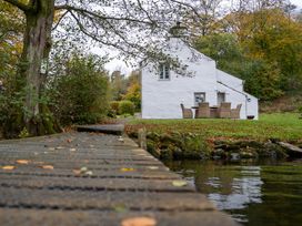 A house with dining area near water at Hullet Hall Graythwaite near Hawkshead