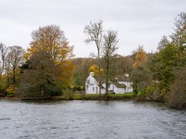 A house beside a river with trees at Hullet Hall in Graythwaite near Hawkshead