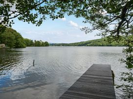 A lake view with a dock and trees at Hullet Hall at the Graythwaite Estate near Hawkshead