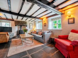 A living room with a sofa, armchair, coffee table and fireplace at Hullet Hall at the Graythwaite Estate near Hawkshead