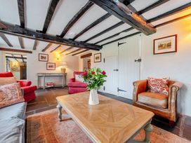 A living room with a sofa, armchair, and coffee table at Hullet Hall at the Graythwaite Estate near Hawkshead
