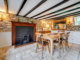 A dining room with a fireplace and wooden table at Hullet Hall at the Graythwaite Estate near Hawkshead