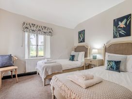 A bedroom with twin beds and a window at Hullet Hall at the Graythwaite Estate near Hawkshead