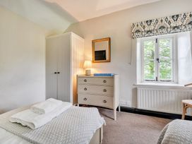A bedroom with a bed, chest of drawers, and window at Hullet Hall at the Graythwaite Estate near Hawkshead