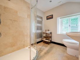 A bathroom with a shower, toilet, and towel storage at Hullet Hall at the Graythwaite Estate near Hawkshead