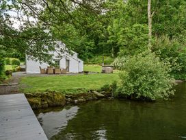 A garden with seating and a hot tub by the lake at Hullet Hall at the Graythwaite Estate near Hawkshead