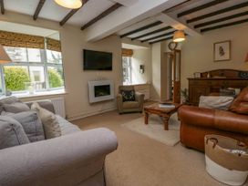 A living room with sofas armchair coffee table and wooden cabinet at Fox Barn in Staveley