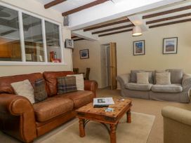 A living room with two sofas a wooden coffee table and framed pictures on the wall at Fox Barn in Staveley