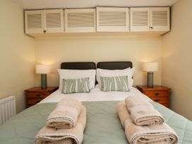 A bedroom with a double bed two bedside tables two lamps and folded towels on the bed at Fox Barn in Staveley