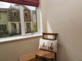 A wooden chair with a cushion featuring ducks placed by a window in a room at Fox Barn in Staveley