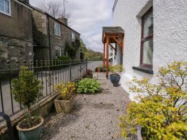 A gravel pathway with potted plants and a wooden porch beside a white building at Fox Barn in Staveley