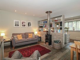 A living room with a sofa and wood stove at The Stable in Deepdean near Ross-on-Wye