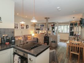 A living room with a couch and bookshelf at The Stable in Deepdean near Ross-on-Wye