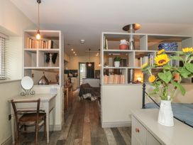 A kitchen with shelves and a dining area at The Stable in Deepdean near Ross-on-Wye