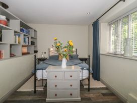 A bedroom with a bed and shelf with books at The Stable Deepdean near Ross-on-Wye