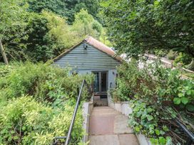 A view of a building surrounded by greenery at The Stable in Deepdean near Ross-on-Wye