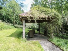 A gazebo with seating and a grill in the garden at The Stable in Deepdean near Ross-on-Wye