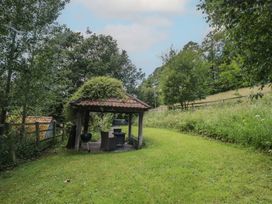 A gazebo with a barbecue and seating in a garden at The Stable Deepdean near Ross-on-Wye
