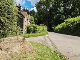 A stone sign and house by a road at The Lodge Farm in Deepdean near Ross-on-Wye