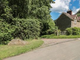 An outdoor view showing The Lodge Farm sign and surrounding greenery near the house in Deepdean near Ross-on-Wye