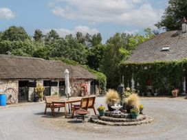 A courtyard with a table and chairs near a barn at Mrs Delaney's Loft Ardfinnan near Clonmel County Tipperary