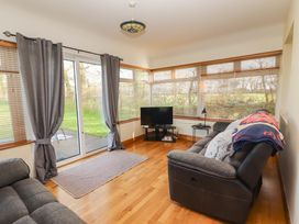 A snug with a television and a sofa at Moybella Lodge, Lisselton near Ballybunion, County Kerry