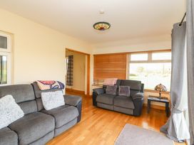 A living room with sofas and a lamp at Moybella Lodge in Lisselton near Ballybunion, County Kerry