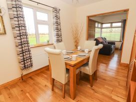 A dining area with a table and chairs at Moybella Lodge in Lisselton near Ballybunion, County Kerry