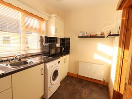 A kitchen with a sink and washing machine at Moybella Lodge in Lisselton near Ballybunion, County Kerry