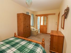 A bedroom with a bed, wardrobe and sofa at Moybella Lodge in Lisselton near Ballybunion, County Kerry