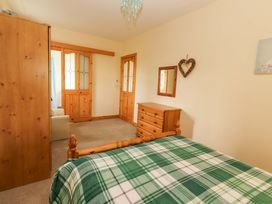 A bedroom with a bed and a wardrobe at Moybella Lodge, Lisselton near Ballybunion, County Kerry