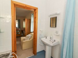 A bathroom with a sink and mirror leading to a bedroom at Moybella Lodge in Lisselton near Ballybunion, County Kerry