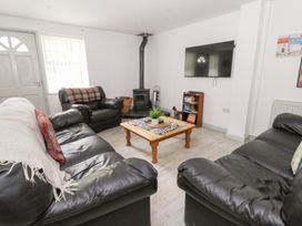 A living room with a wooden coffee table and television at Cariad Cottage in Cross Inn