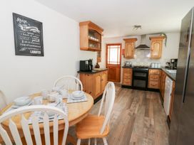 A kitchen with a table and chairs at Cariad Cottage in Cross Inn