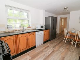 A kitchen with a sink and appliances at Cariad Cottage in Cross Inn