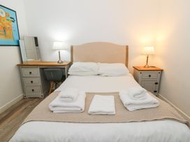A bedroom with a bed and lamps at Cariad Cottage in Cross Inn