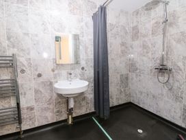 A bathroom with shower, sink, and towel rail at Cariad Cottage in Cross Inn