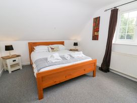 A bedroom with a bed and bedside table at Cariad Cottage in Cross Inn