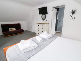 A bedroom with a bed and television at Cariad Cottage in Cross Inn