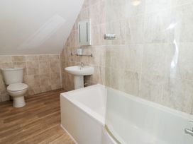 A bathroom with a sink, bathtub and toilet at Cariad Cottage in Cross Inn