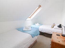 A bedroom with two beds and a window at Cariad Cottage in Cross Inn
