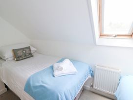 A bedroom with a single bed and window at Cariad Cottage in Cross Inn