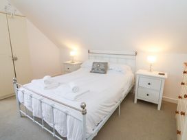 A bedroom with a bed and nightstands at Cariad Cottage in Cross Inn