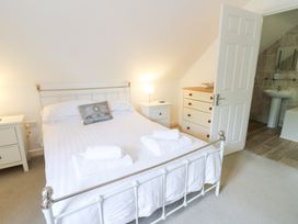 A bedroom with a bed and nightstands at Cariad Cottage in Cross Inn