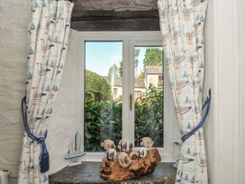 A living room with a window and curtains at Wagtail Cottage East Taphouse