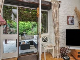 A living room with door and view of garden at Wagtail Cottage in East Taphouse