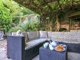A garden area with a sofa, coffee table, and breakfast items at Wagtail Cottage East Taphouse